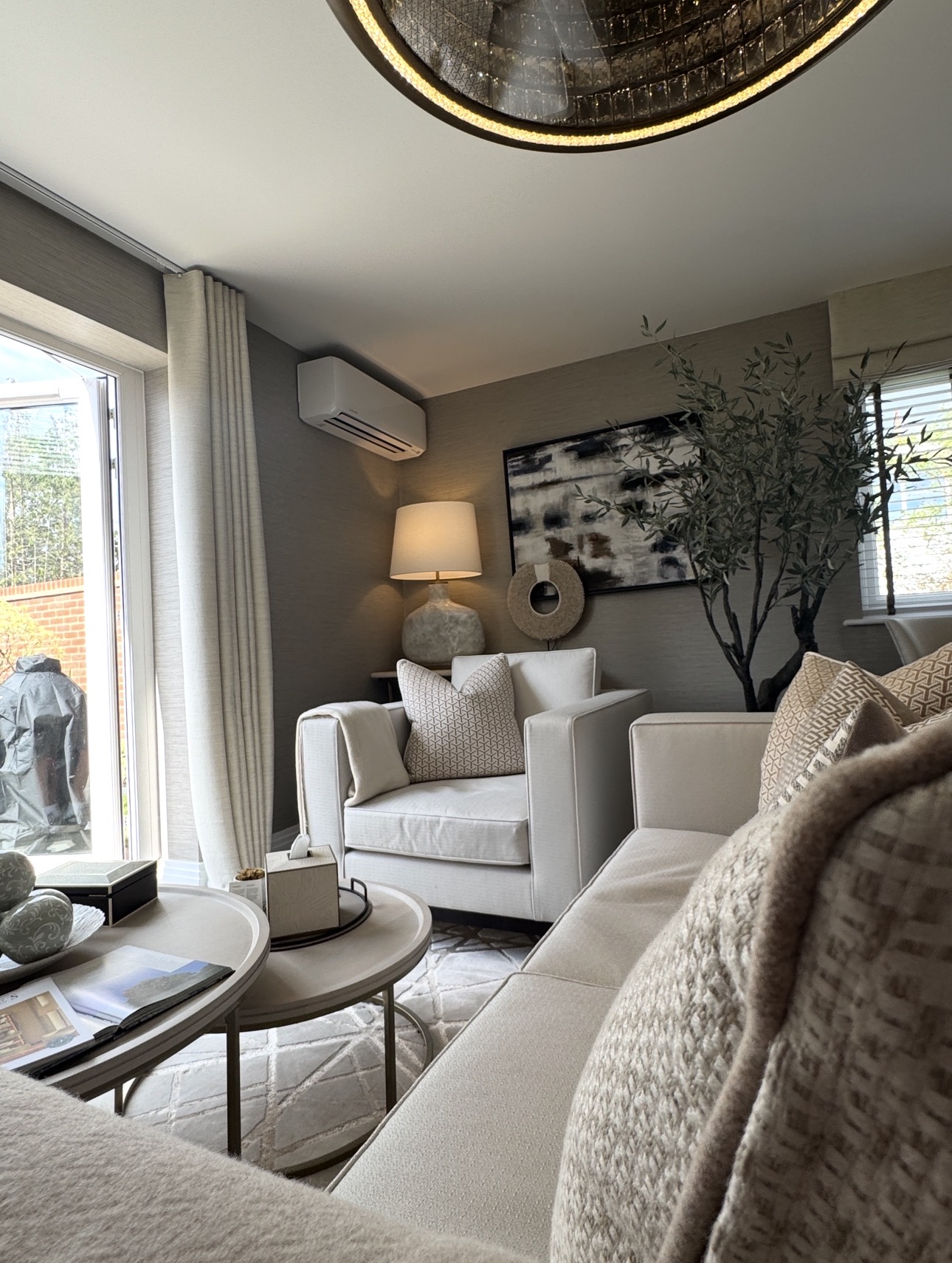 Wall-mounted air conditioning unit above a window in a styled living room