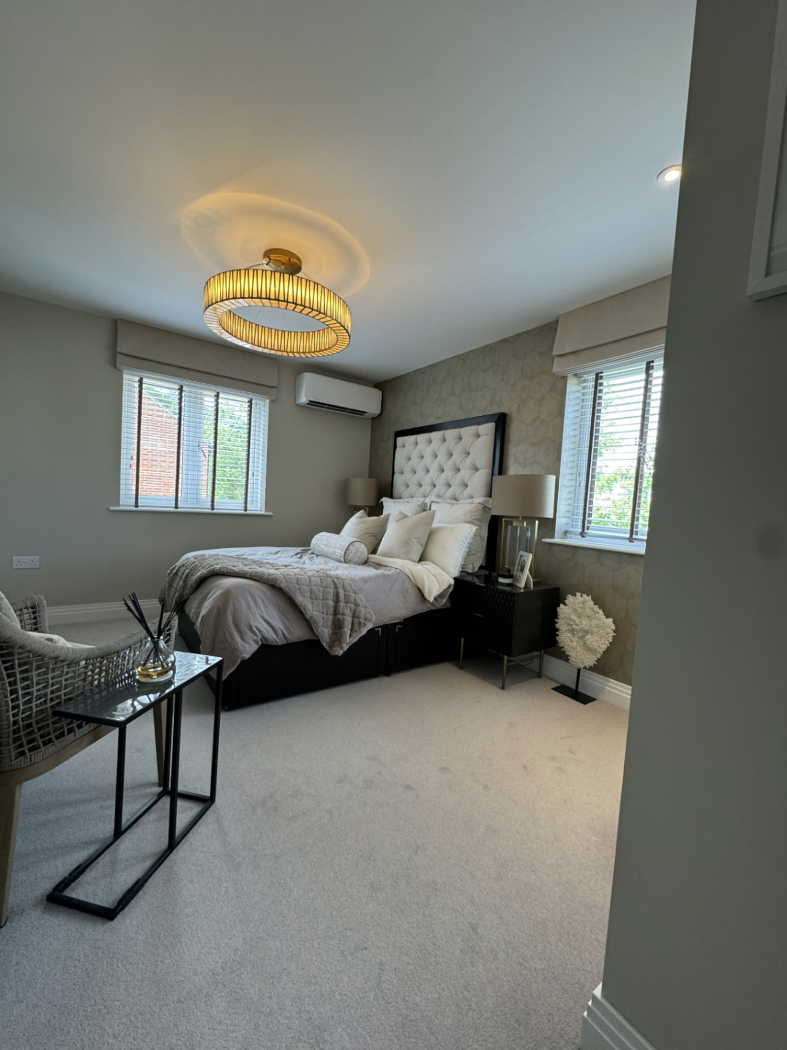 Bedroom air conditioning unit fitted on the wall beside a feature headboard